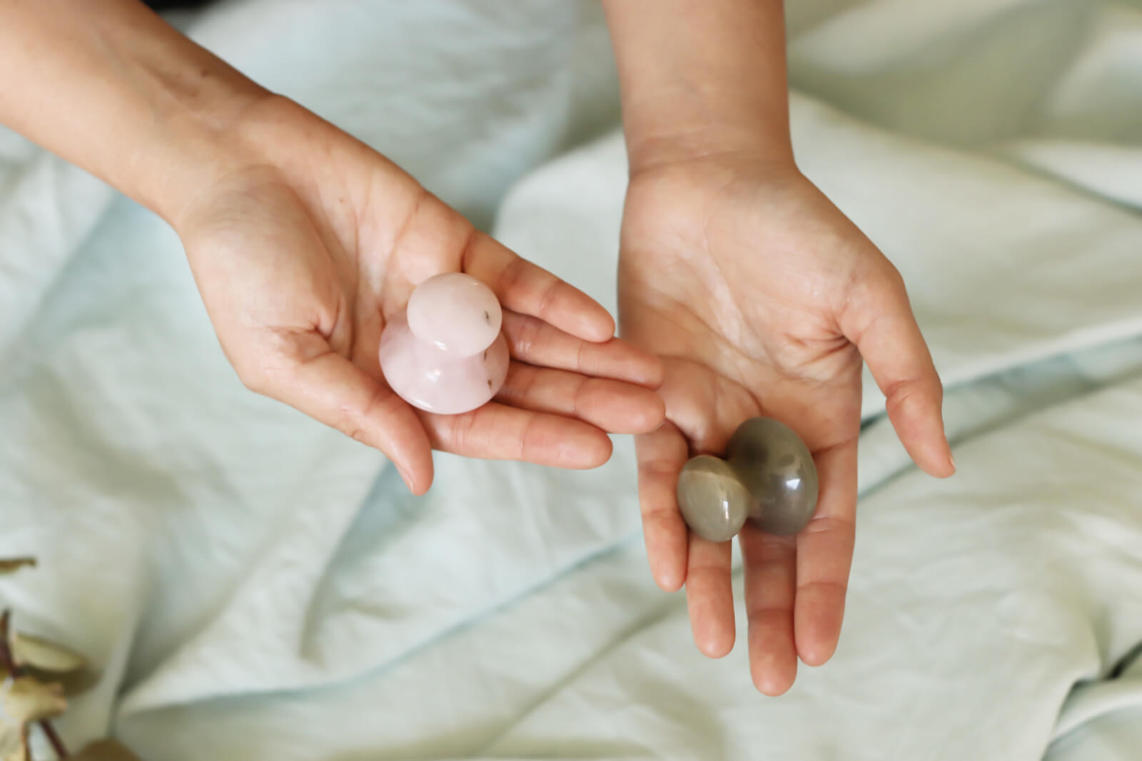 Hands holding up gua sha stones