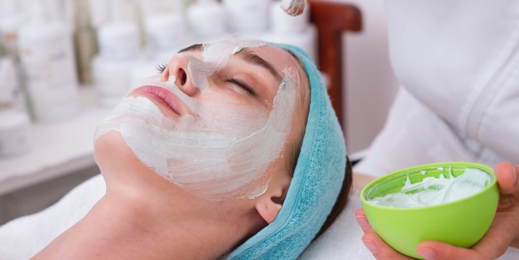 Woman lying down receiving a facial treatment